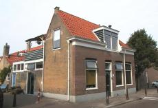 Hoekpand Korendijkstraat 145 met links daarvan gedeelte van hofje genummerd 147 en hoger