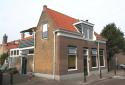Hoekpand Korendijkstraat 145 met links daarvan gedeelte van hofje genummerd 147 en hoger